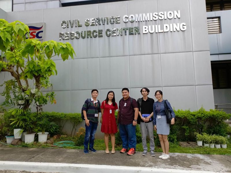 UPOU OSA Director Ria Mae Borromeo and the UPOU USC pose for a photo in front of the Civil Service Commission Resource Center Building.